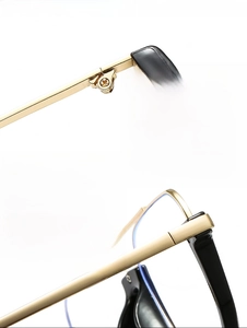 Detail of gold metal hinge and black textured frame on oversized square blue light glasses