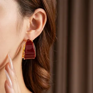 Vintage gold plated resin hoop earrings in deep red, shown worn by a fashion model