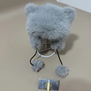 Detailed view of grey faux fur trapper hat with cute ears and plush pompom ties
