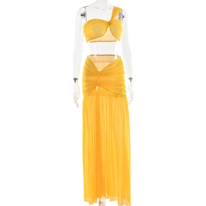 Detail of yellow two-piece set featuring twisted bandeau top and high waist mesh maxi skirt