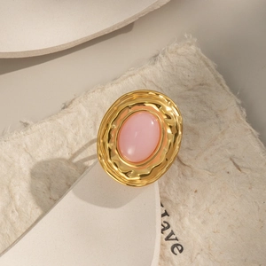 Detail of pink natural stone ring with textured gold finish on organic metal base