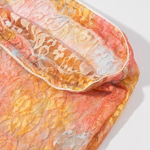 Detail of vibrant orange and pink lace mesh fabric with fine stitching and translucent texture