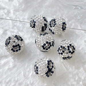 Close-up of sparkling black and white rhinestone round disco beads for DIY jewelry making