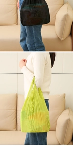 Detail of expandable pleated texture and large capacity of shopping bags in black and neon green