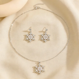 Details des silbernen Schneeflocken-Schmucksets mit Perlen und Kristallen auf Stoff