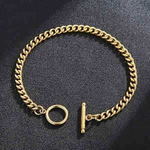 Golden stainless steel Cuban link bracelet with stylish OT toggle clasp on black surface