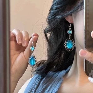 Vintage oval sky blue resin earrings with ornate silver lace framing worn by model