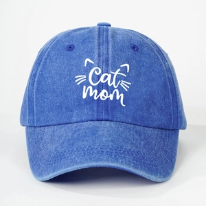 Macro detail of 'Cat mom' embroidery and feline line art on washed denim baseball cap