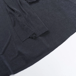 Dettaglio macro della morbida trama in maglia grigio scuro per questo abito aderente allacciato