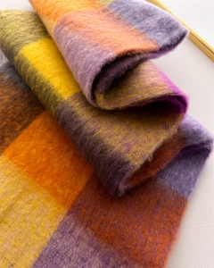 Close-up of warm purple and orange plaid scarf with a soft brushed mohair texture