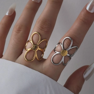 Close-up of cutout flower rings in gold and silver finish on a model's hand