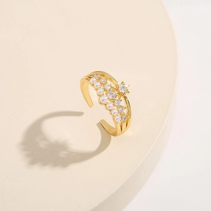 Detail of adjustable gold ring with pearls and star-shaped zircon on a beige pedestal