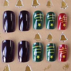Christmas press-on nails with purple, green and red holiday tree designs on beige background