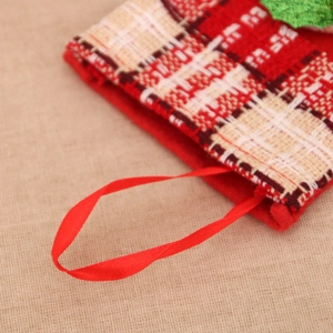 Detailed close-up of a red satin hanging loop and plaid knit edge on a Christmas stocking