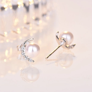 Detailed macro view of an elegant pearl earring with zircon moon accent and silver base