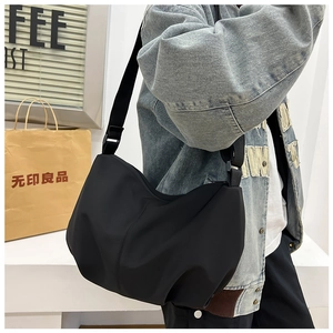 Detail view of black nylon hobo bag showing minimalist ruched style and adjustable strap