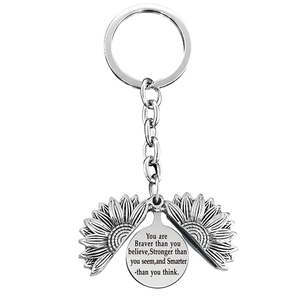 Detail of opening sunflower keychain with engraved inspirational quote inside