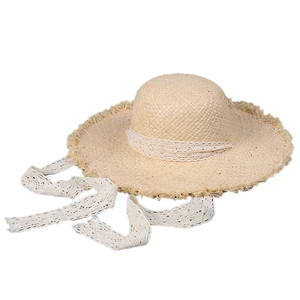 Pastoral straw sun hat with white lace ribbon and frayed edges for beach vacation