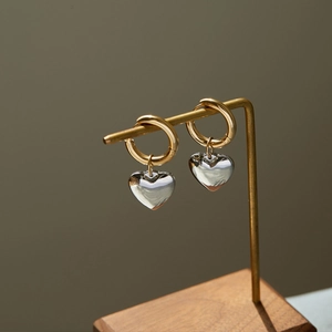 Elegant gold hoop earrings with silver heart charms in a polished stainless steel finish