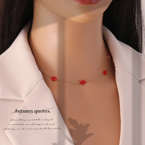 Elegant gold titanium steel necklace with red lip heart pendant worn by model