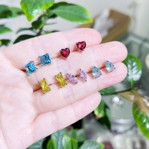 Detailed view of colorful zircon stud earrings set with multiple shapes and silver plating