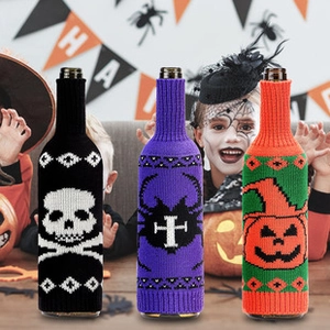 Close-up of Halloween knit wine bottle covers with skull, pumpkin and cross designs