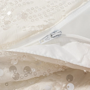 Vista macro del tessuto di paillettes bianche e cerniera invisibile sui pantaloni