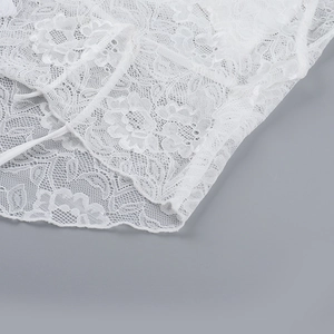 Détail de la texture en dentelle florale blanche et finitions soignées du haut dos nu