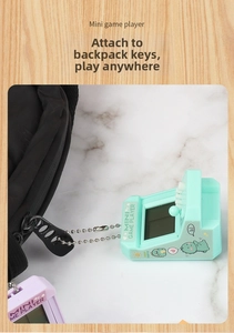 Macro view of mint green mini arcade game keychain attached to a black backpack