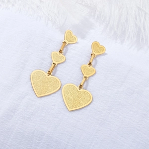 Boucles d'oreilles pendantes à trois cœurs dorés avec texture mate sur fond blanc
