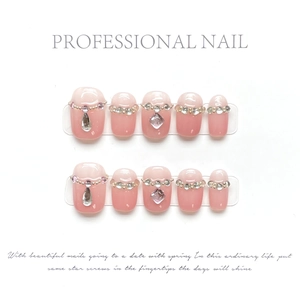 Macro detail of handmade press-on nails with pink gradient and luxury rhinestone gems