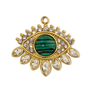 Detail of a vintage gold Evil Eye pendant featuring malachite-style beads and crystals