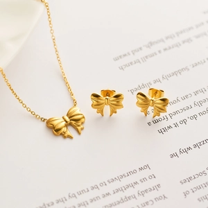 Golden ribbon bow jewelry set featuring a delicate necklace and matching stud earrings