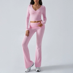 Pink knit two-piece set featuring V-neck long sleeve crop top and flared trousers