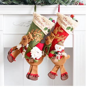 Detailed view of plush Christmas stockings with Santa and Reindeer on a white fireplace