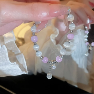 Detail of pink and white cat eye stone beads with silver star pendant bracelet
