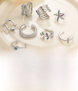 Détails macro de boucles d'oreilles serpent et étoile en argent avec zircons colorés