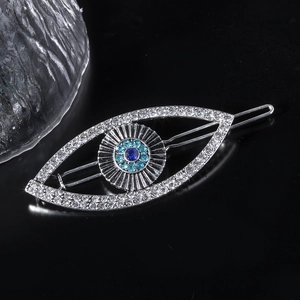 Detail of silver hair clip featuring evil eye design with blue gems and rhinestones