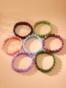 Vue macro détaillée de sept bracelets colorés en pierres naturelles avec ombres douces de vagues