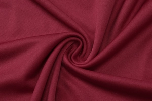 Close-up of wine red fabric texture with pleated details and soft knit pattern