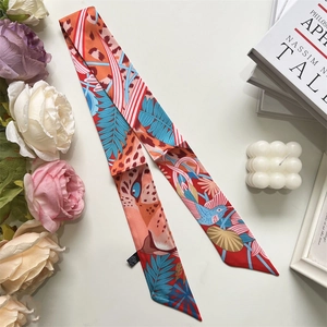 Detail of red and orange silk twilly scarf with tropical rainforest and leopard print