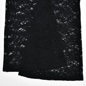 Close-up of the intricate black floral lace pattern and sheer fabric of this jumpsuit