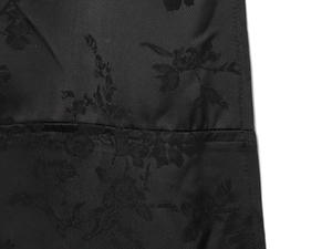 Détail du tissu jacquard noir avec des motifs de broderie florale élégants sur la robe