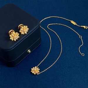 Elegant gold lotus jewelry set with sparkling crystals featuring floral studs and necklace