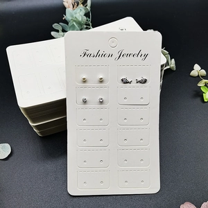 Detail of multi-pair stud earring set on white display card with floral decor