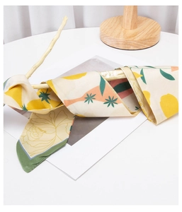 Detail view of colorful floral twilly scarf wrapped on wood with satin silk texture