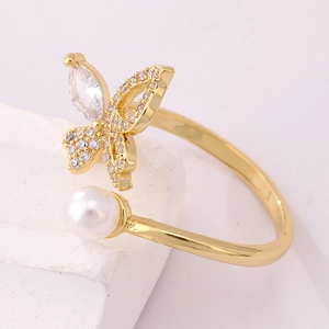 Detailed view of 18K gold butterfly ring featuring zircon pavé and a white pearl