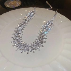 Detail of silver rhinestone choker necklace featuring sparkling crystals on white ceramic