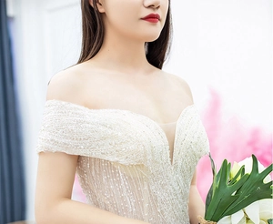 Detail of off-shoulder wedding gown with luxury sequins and intricate beadwork embroidery