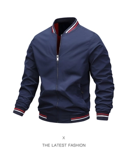 Detail of navy blue bomber jacket with red and white striped ribbed cuffs and collar